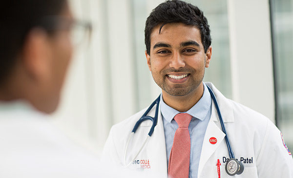 A healthcare student in white lab coat with stethoscope